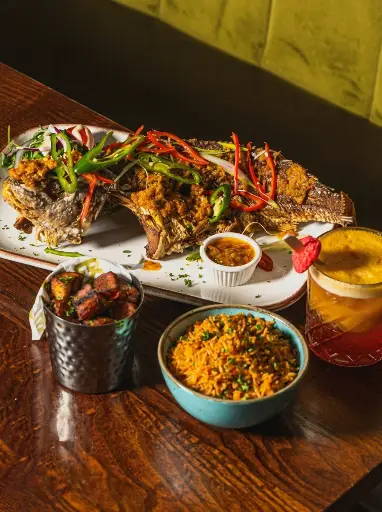 Whole grilled fish with sides and a cocktail at ESQ