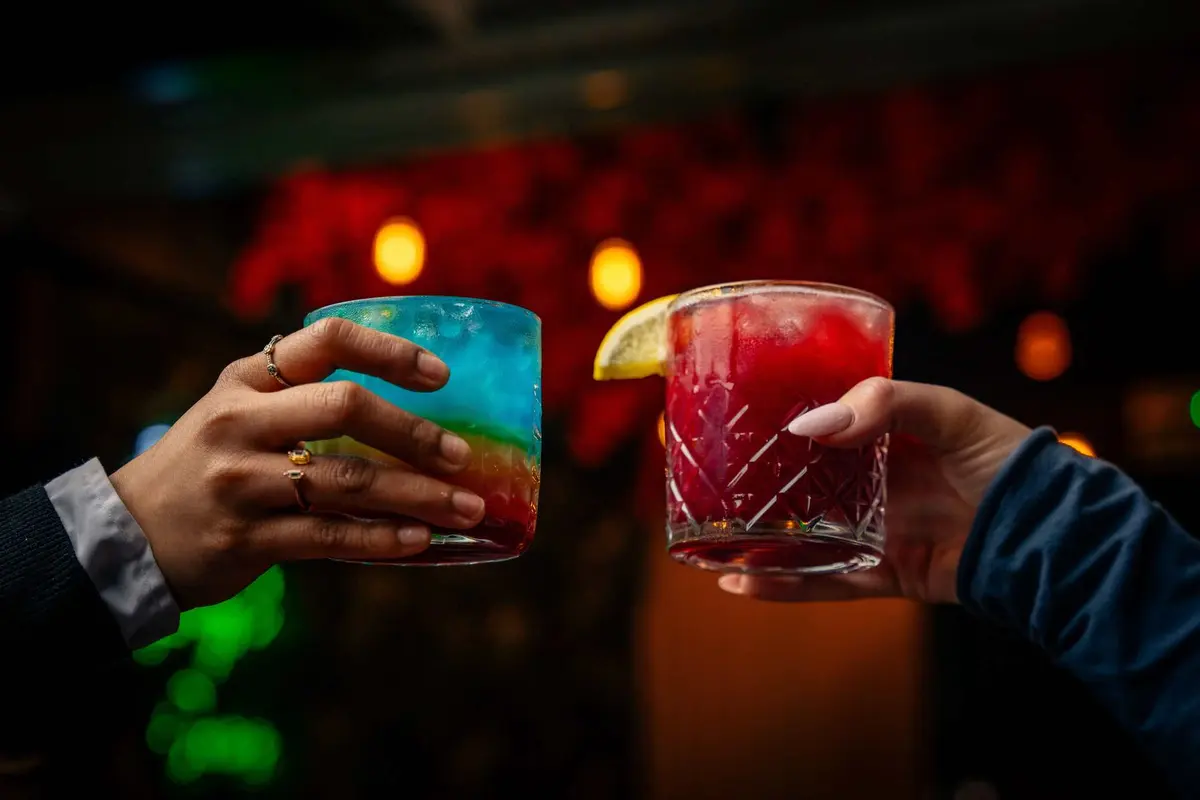 Friends raising colourful cocktails at ESQ