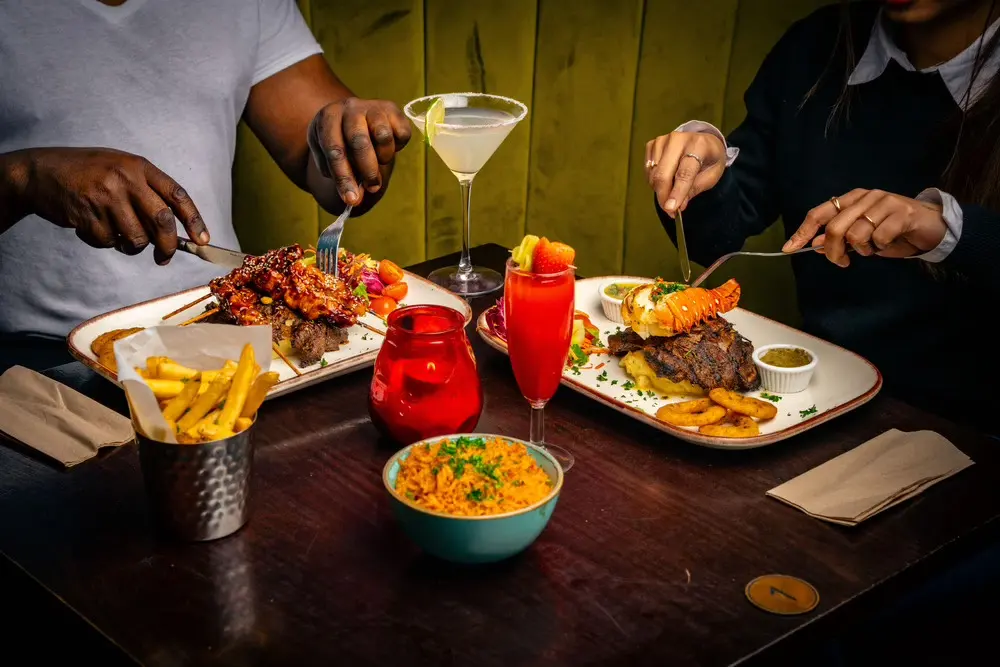 Friends sharing food and cocktails around a table at ESQ